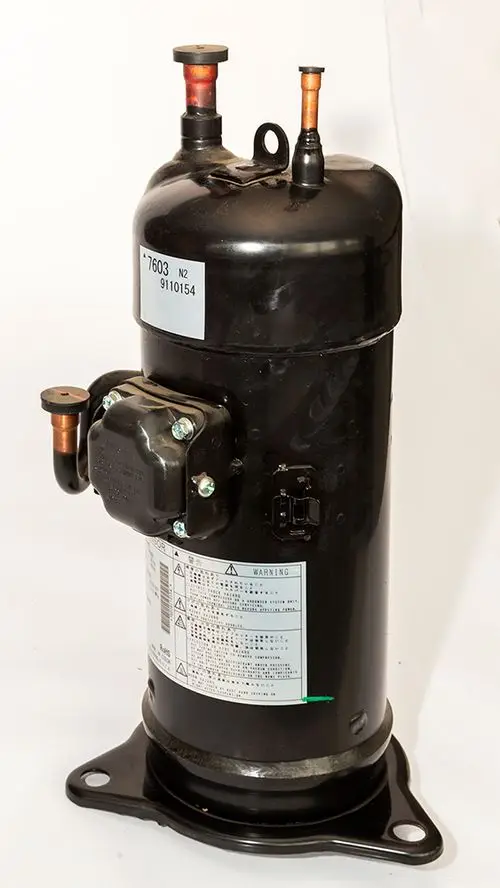 Schwarzer Daikin-Kompressor mit zwei Kupferanschlüssen und beschriftetem Typenschild. Sichtbare Anschlussstellen und Montageflansch unten.